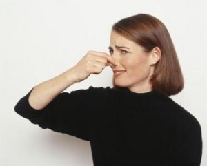 鼻をつまむ女性